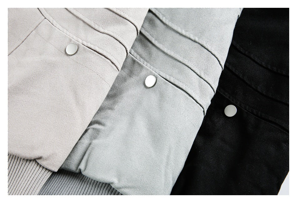 Close-up of three jacket colorways in beige, light gray, and black, each with a round snap.