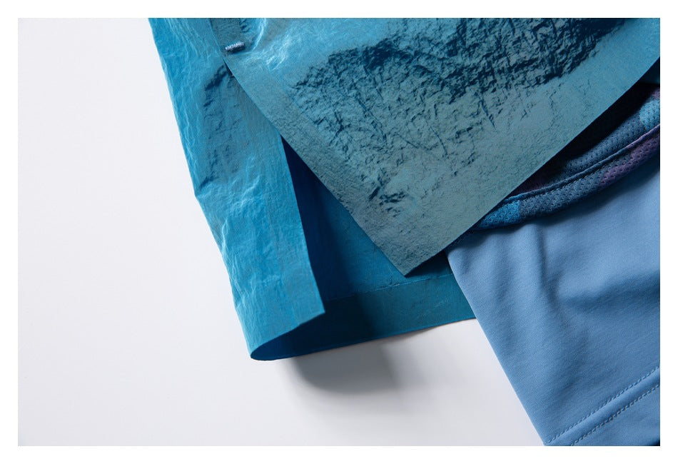 Close-up showing the turquoise shorts' outer hem layered over a light blue inner short.