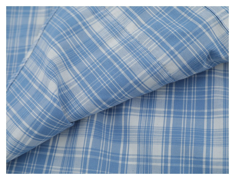 Close-up of blue-and-white plaid shirt fabric, showing its check pattern and texture.
