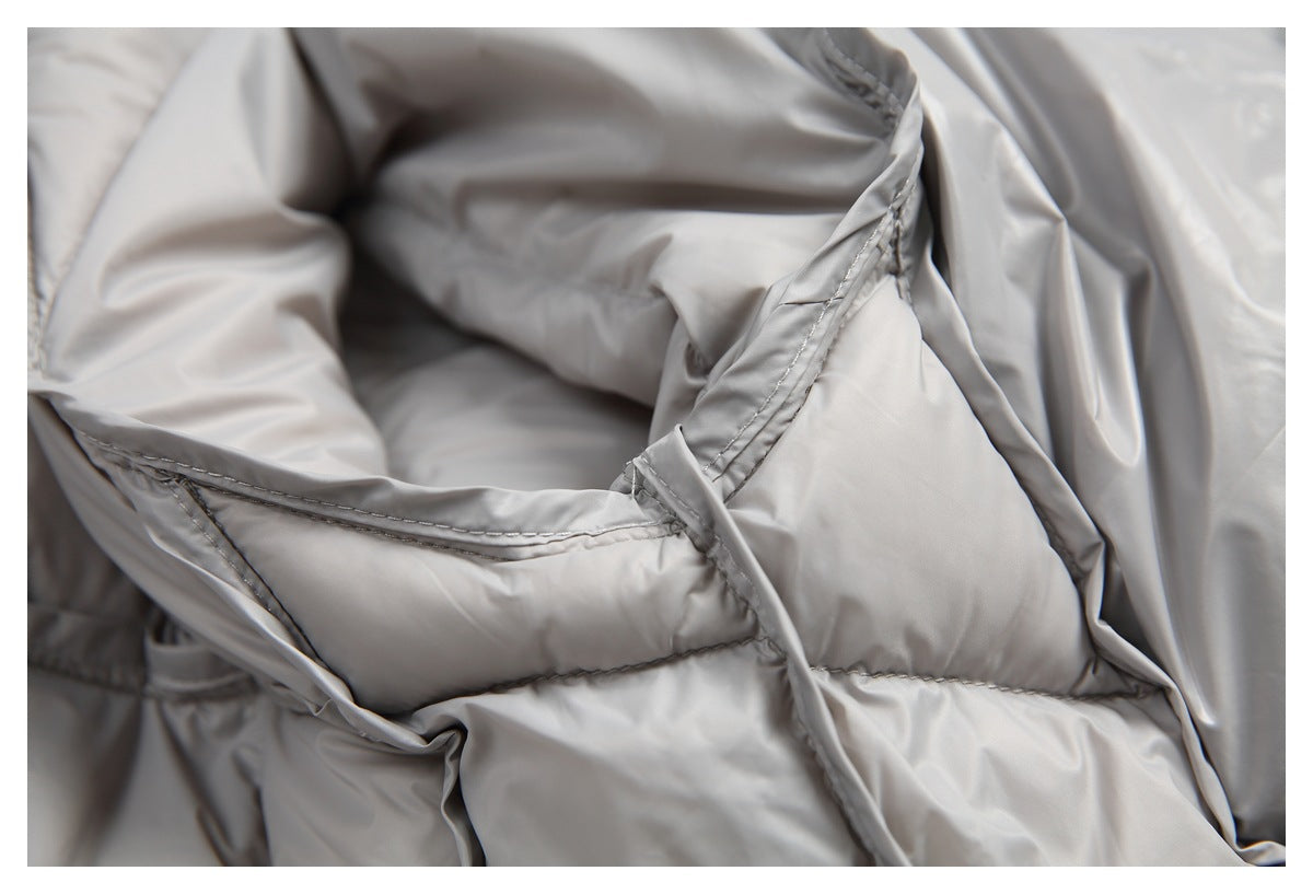 Close-up of light gray jacket construction, with padded sections and stitched seams.