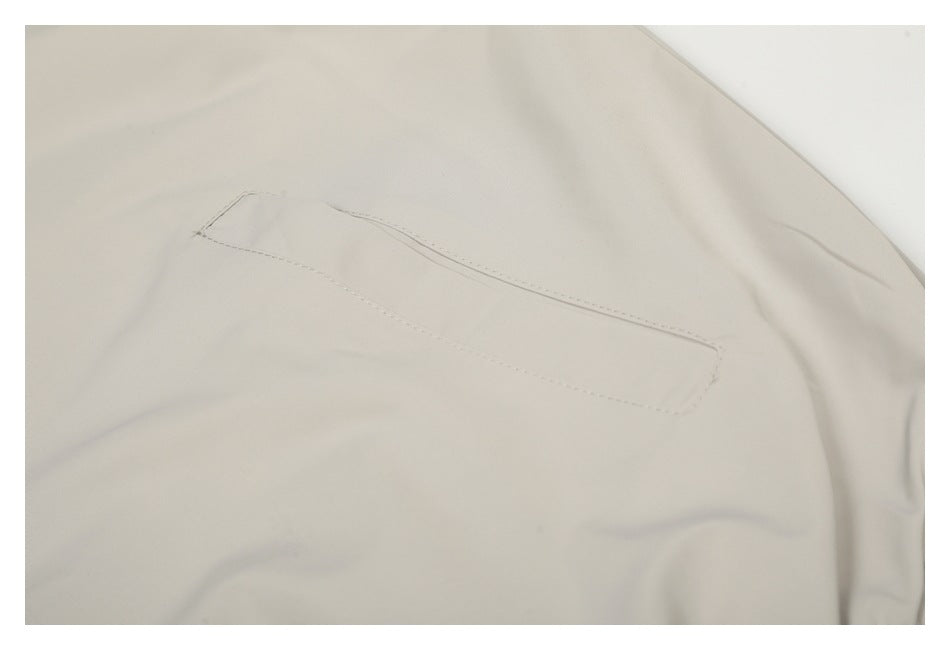 Close-up of a stitched welt pocket on the ivory jacket.