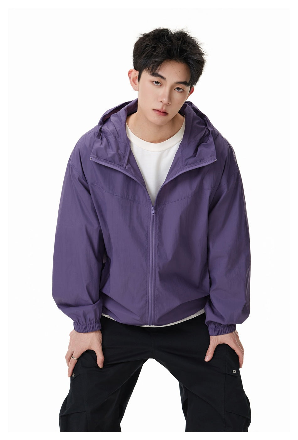 Model wearing an open purple hooded zip jacket over a white shirt, shown from the front.