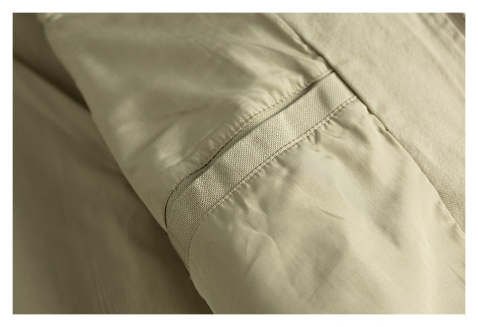 Close-up of a beige garment seam with a stitched fabric panel and reinforced band.