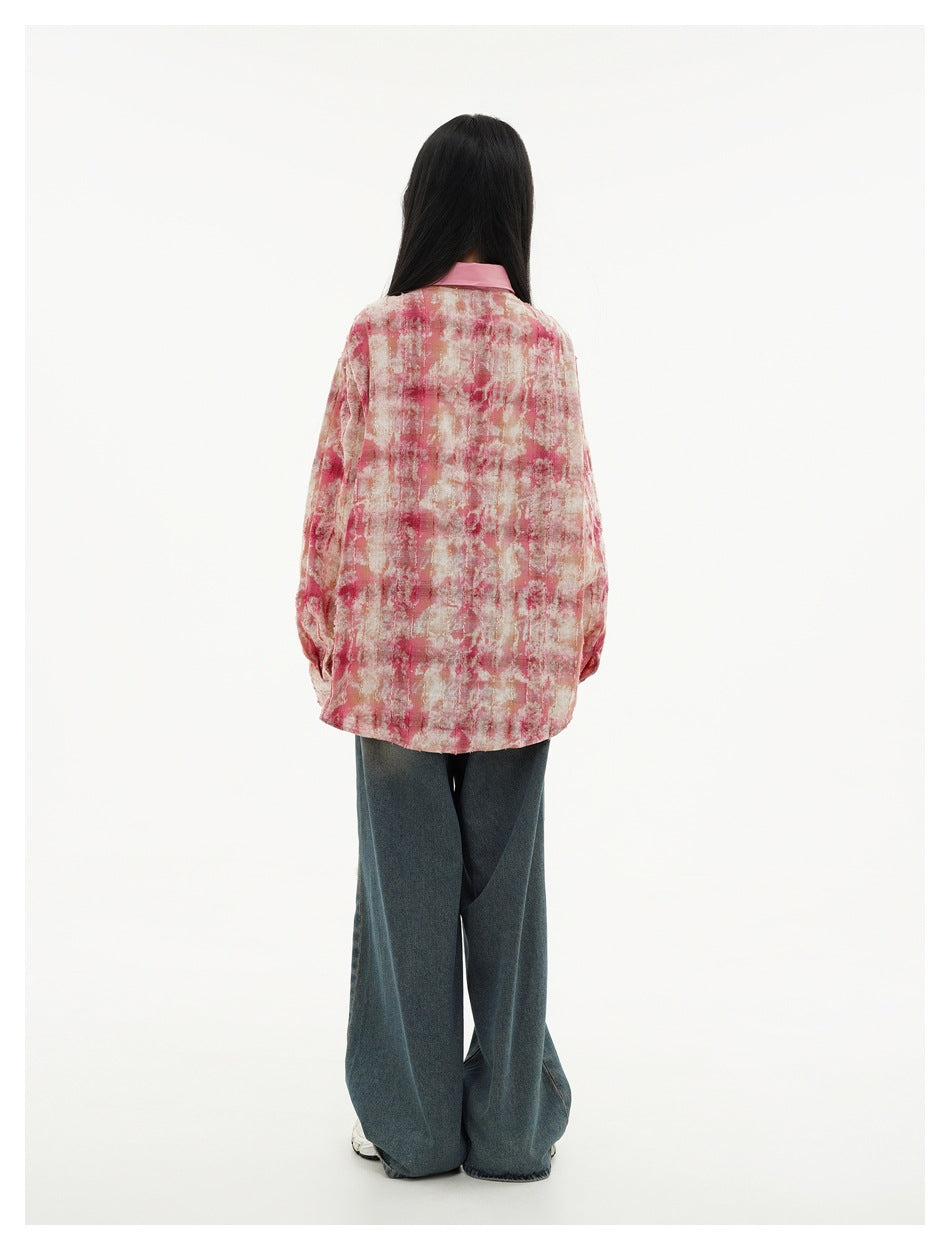 Back view of a model wearing a pink tie-dye plaid long-sleeve shirt with wide-leg jeans