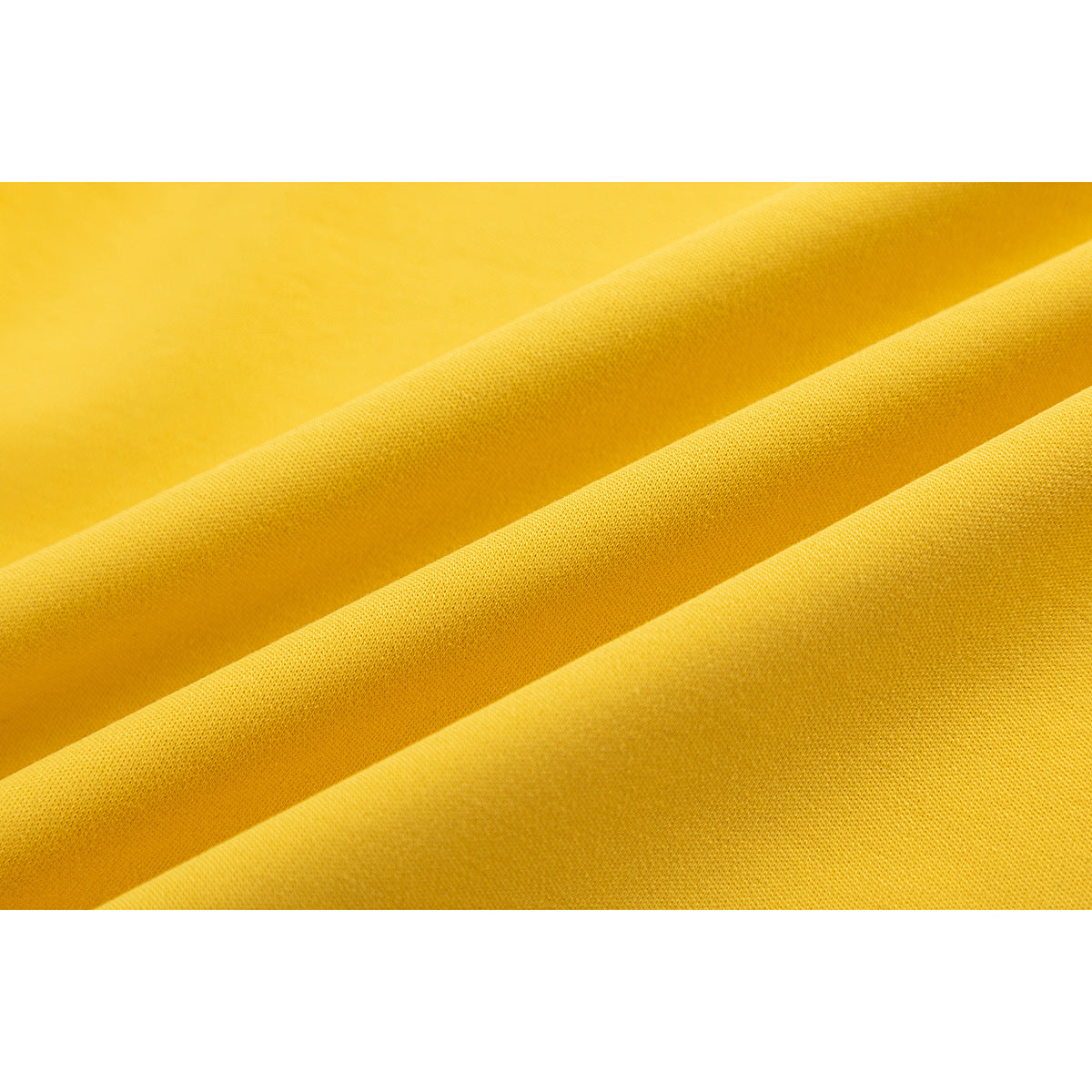 Close-up of yellow fabric arranged in soft folds, showing its knit texture.
