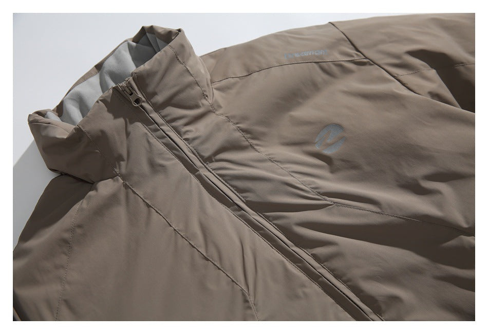 Close-up of the jacket’s high collar, zipper, chest emblem, and small embroidered lettering.