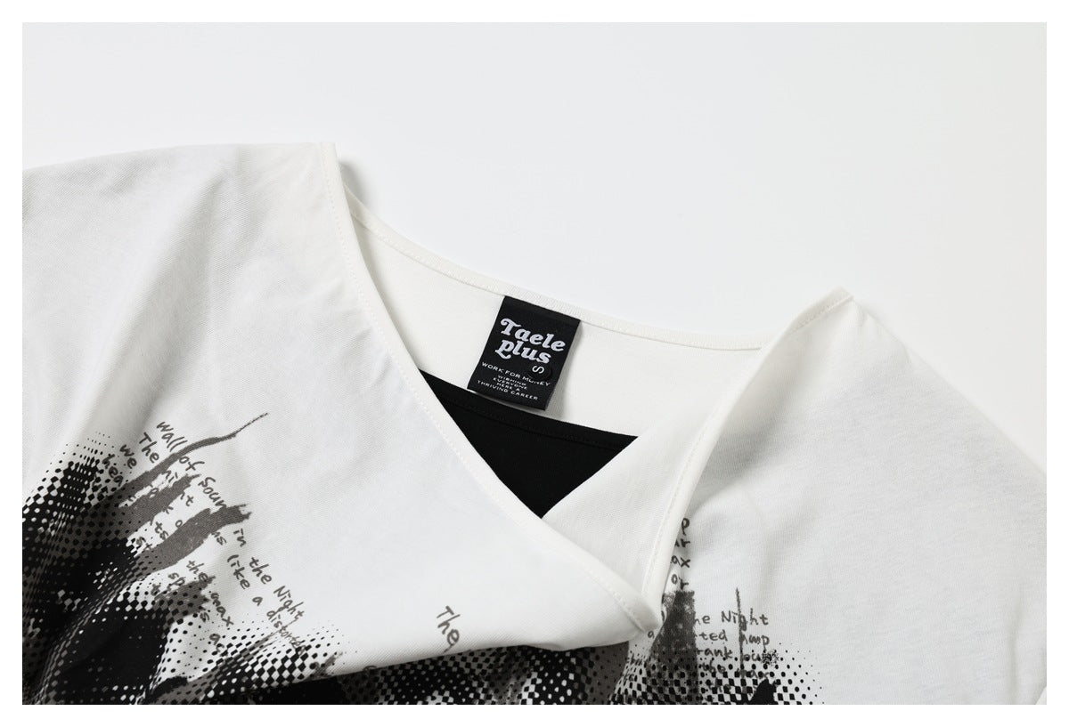 Close-up of a white V-neck garment with black contrast fabric, a neck label, and part of a printed graphic.