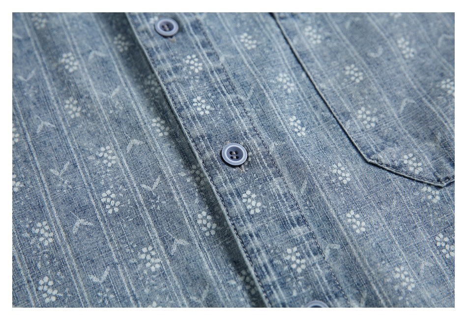 Close-up of the blue patterned shirt's button placket and chest pocket edge.