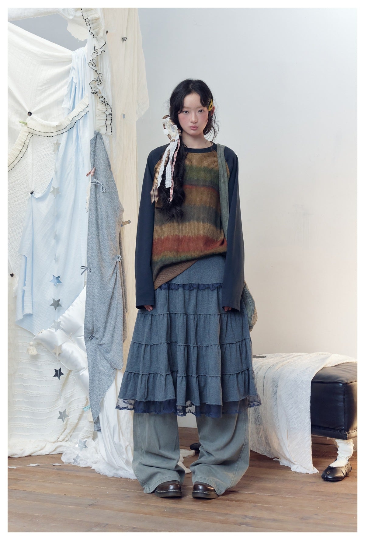 Model wearing navy striped raglan long-sleeve top with a tiered skirt and wide-leg pants, front view