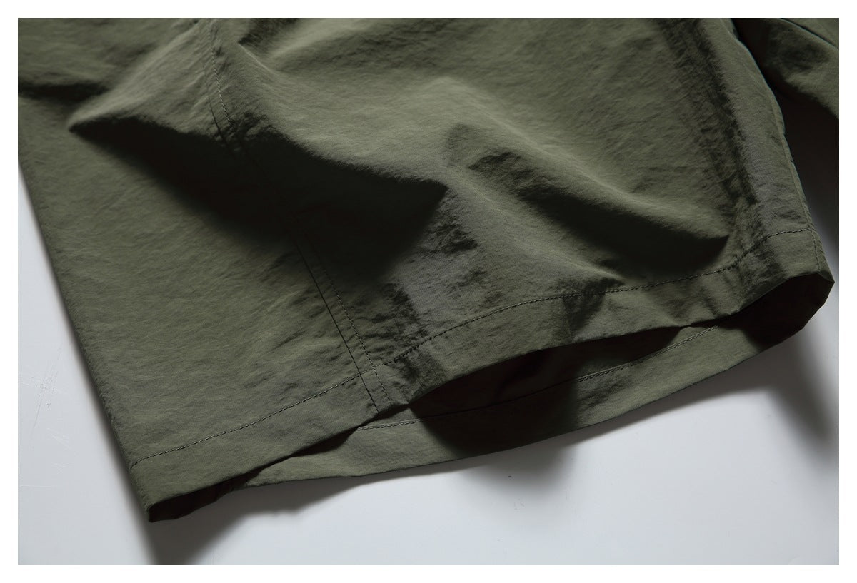Close-up of the olive shorts' hem and stitching.