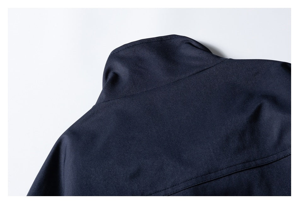 Close-up of the dark navy jacket's raised collar and upper back seam.