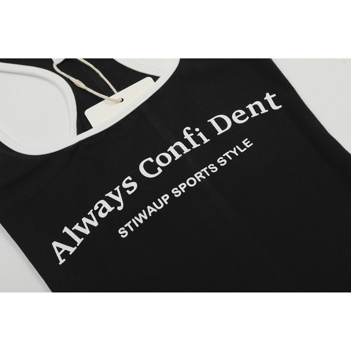 Close-up of white English lettering printed on a black tank top, with part of its white-trimmed neckline visible.