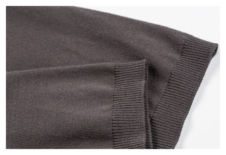 Close-up of charcoal gray knit fabric and two ribbed garment edges.