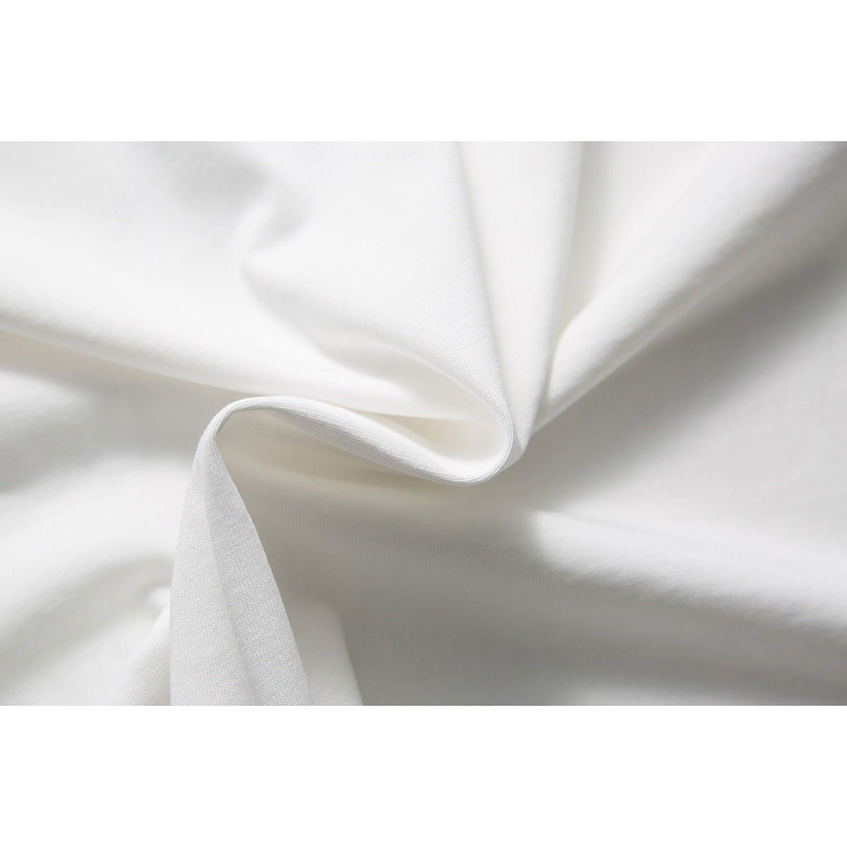 Close-up of white fabric folded into soft folds, showing its surface texture.