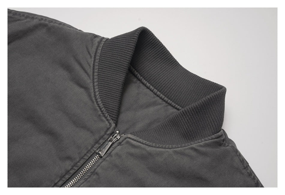 Close-up of a charcoal jacket's ribbed collar and silver front zipper.