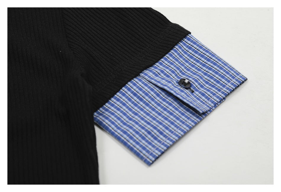 Close-up of a black rib-knit sleeve with a blue plaid cuff and dark button.