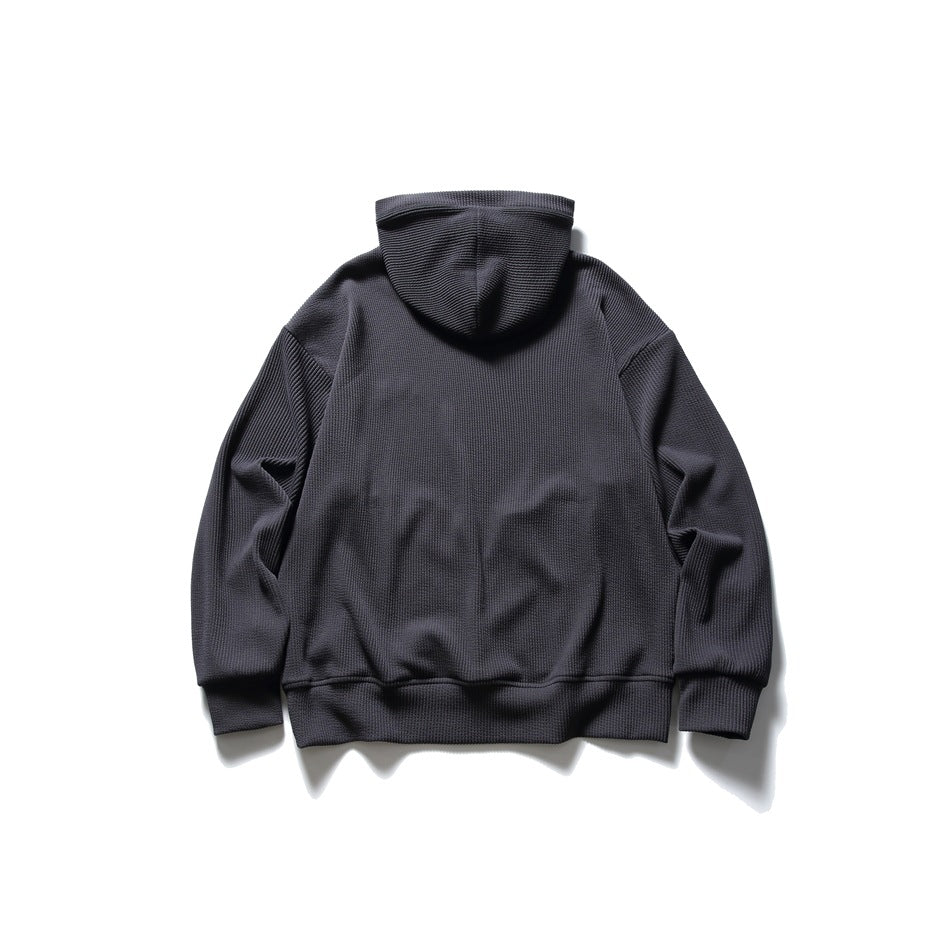 Charcoal gray waffle-knit hoodie flat lay, back view showing hood, drop shoulders and ribbed hem