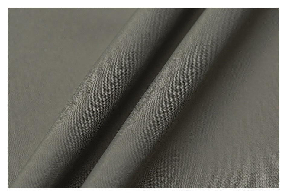 Close-up of smooth gray-olive fabric folded to show its fine woven texture.