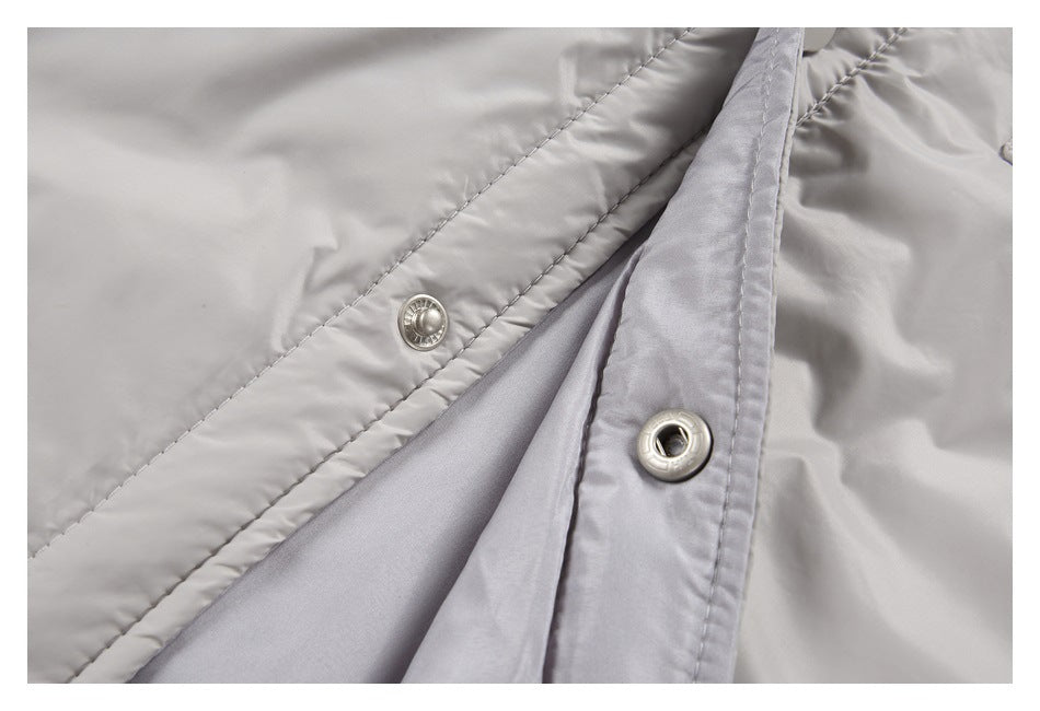 Close-up of the light gray jacket's open snap-button front placket and smooth inner lining.