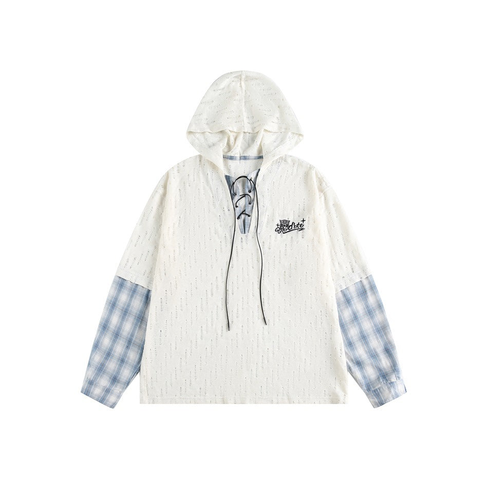 Beige distressed knit hooded top with lace-up neckline, blue plaid sleeves and black chest embroidery, flat lay
