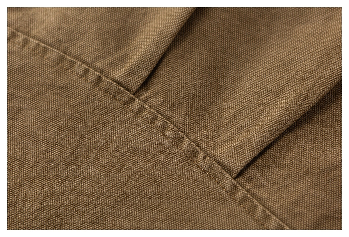 Close-up of brown textured garment fabric and a diagonal stitched seam.