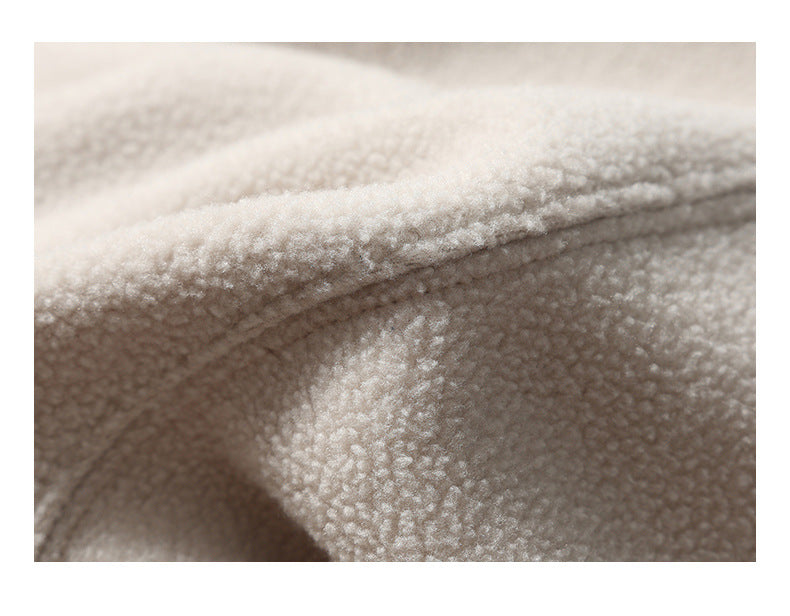 Extreme close-up of the soft, nubby texture of ivory plush fabric.