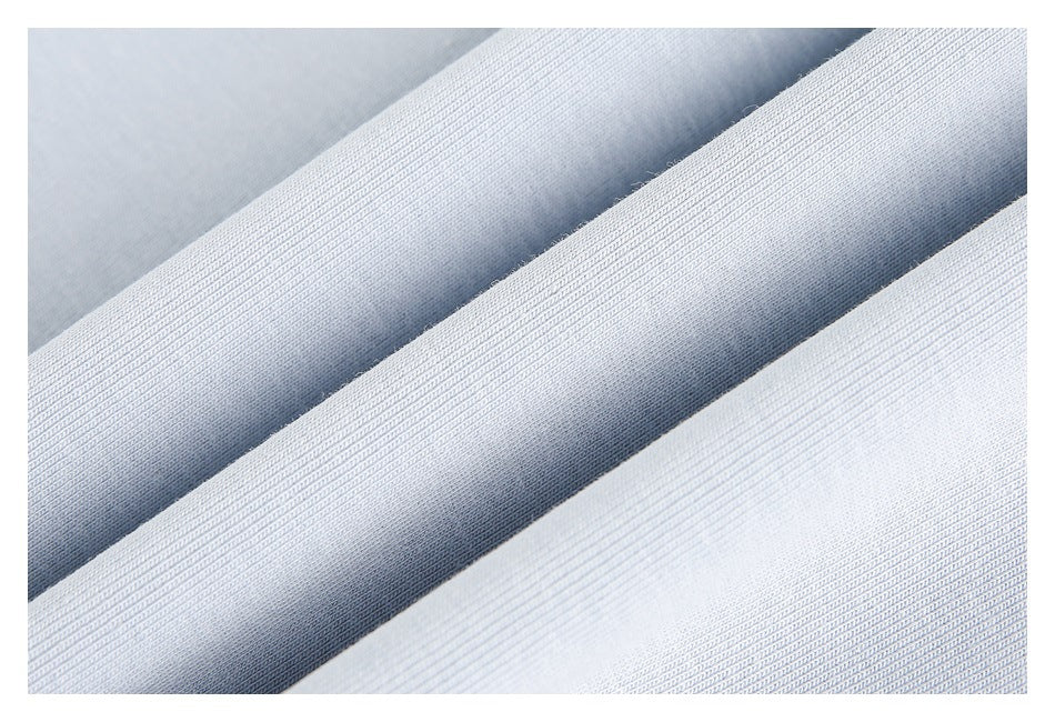 Close-up of pale blue garment fabric arranged in folds, showing its knit texture.