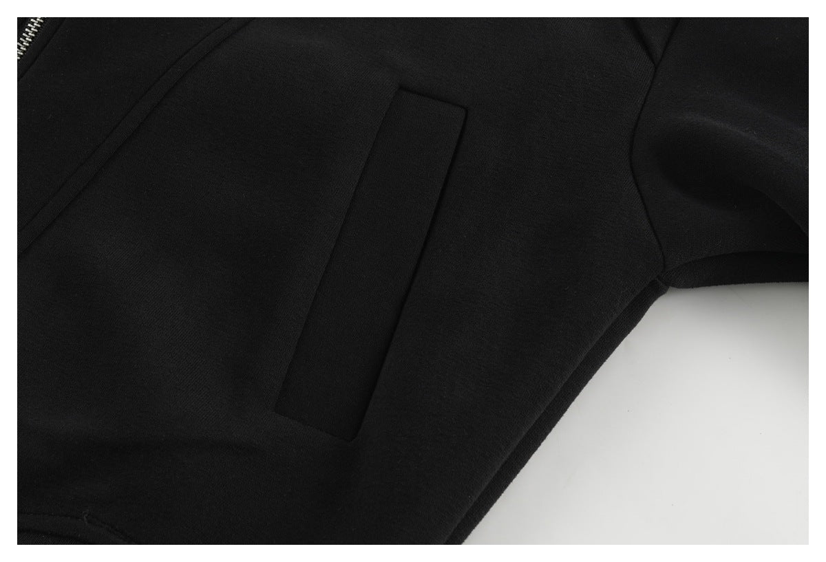 Close-up of a rectangular pocket and curved seam on the black jacket.