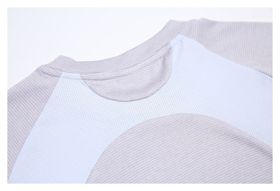 Close-up of the shirt's crew neckline and white perforated mesh panel against pale gray-lavender fabric.