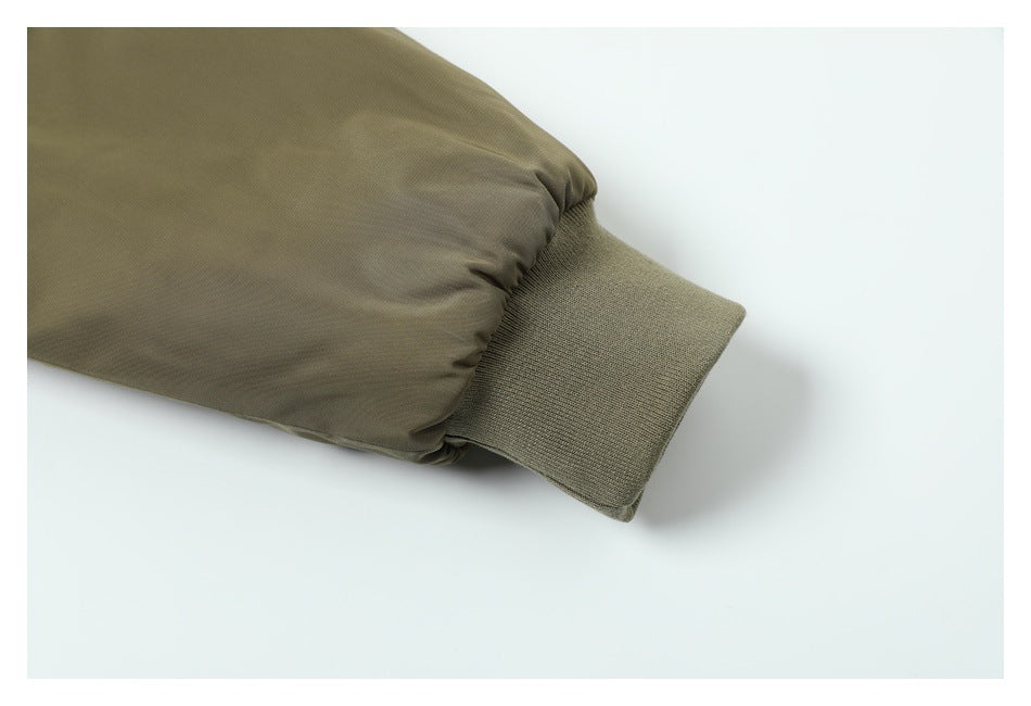 Close-up of an olive sleeve ending in a wide rib-knit cuff.