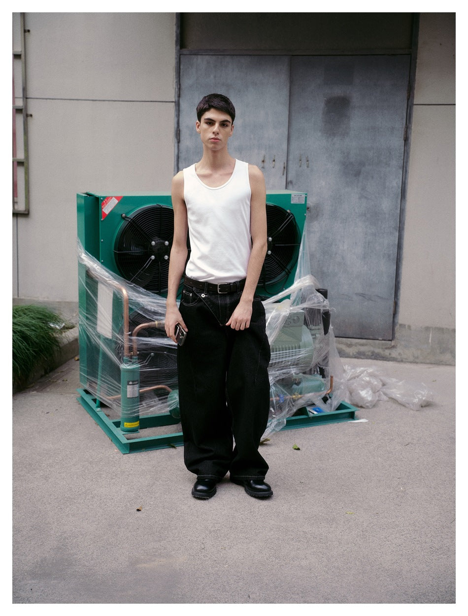 Full-length model wearing a white tank top and black wide-leg jeans with a belt, facing forward outdoors.