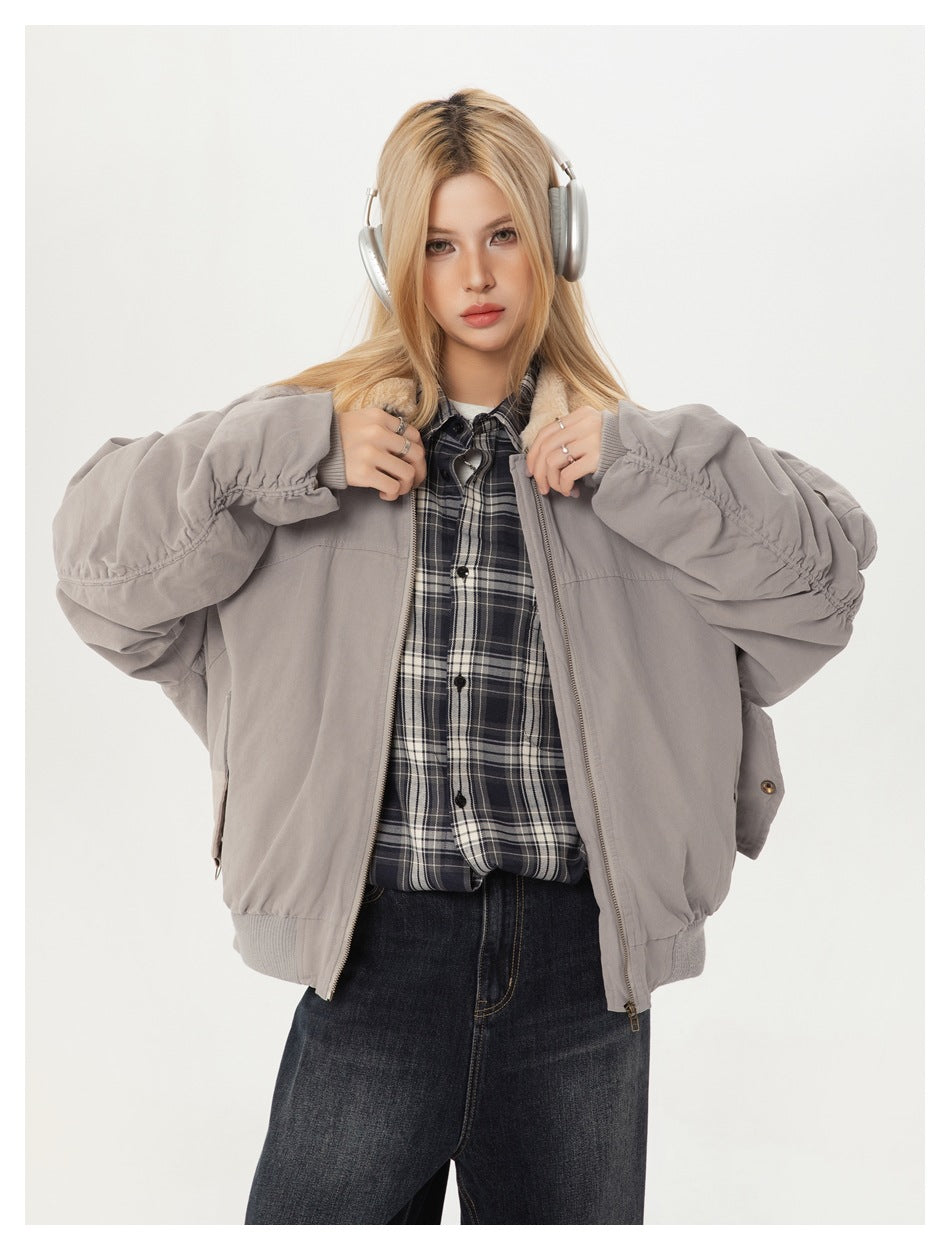 Model wearing an open light gray bomber jacket with a cream collar, front view.