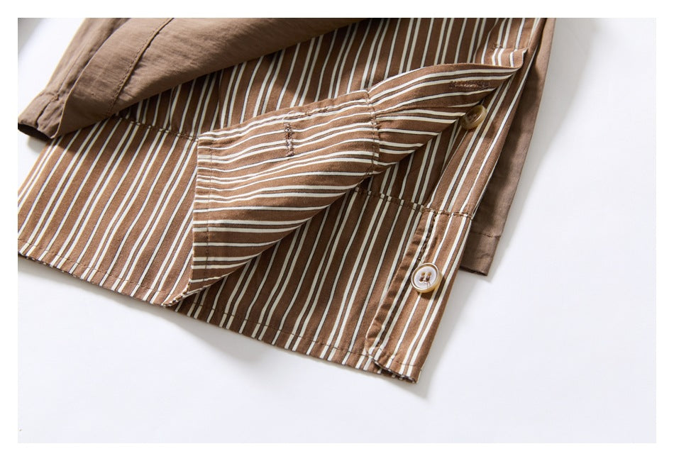 Inside view of the taupe trouser hem, showing striped lining, a folded flap, and button closures.
