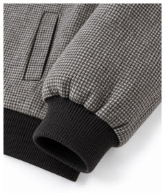 Close-up of a micro-check sleeve cuff with black ribbed trim and a nearby welt pocket.