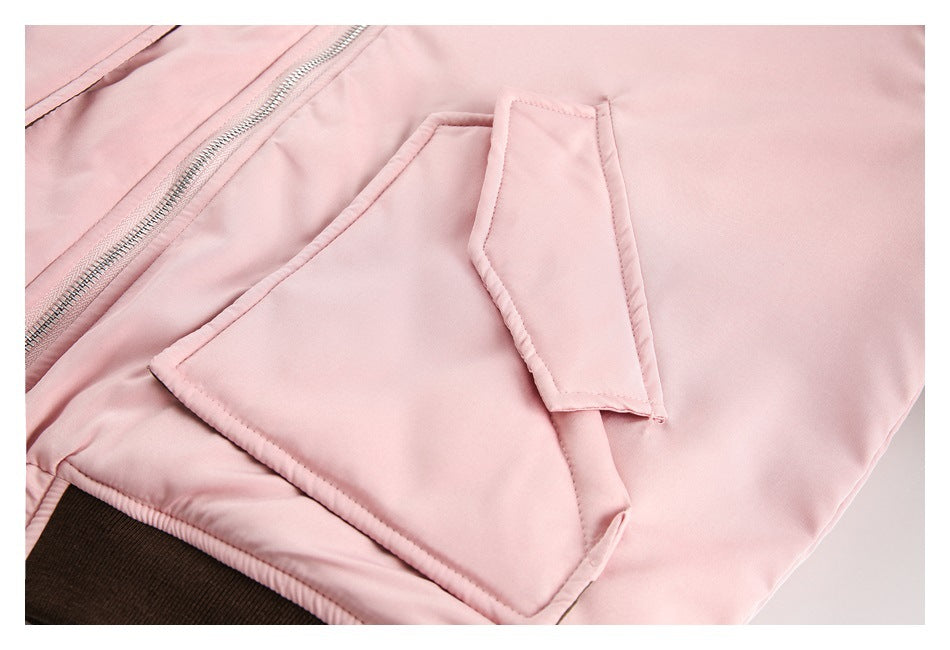 Close-up showing a large flap pocket and zipper on the pale pink jacket.