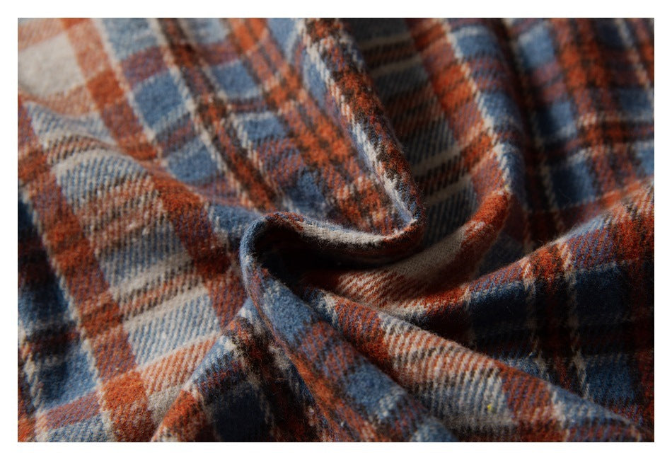 Close-up of rust, navy and cream plaid fabric folded to show its textured surface.