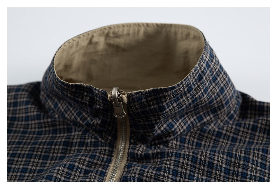 Close-up of the jacket's plaid stand collar, beige lining and front zipper.