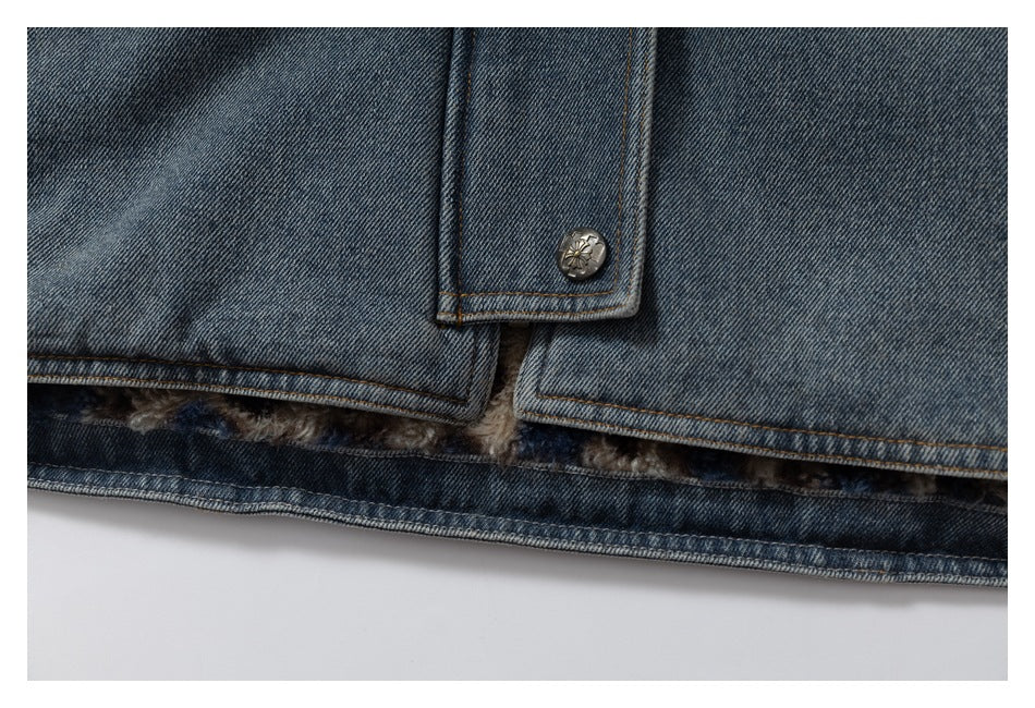 Close-up of a blue denim jacket hem, buttoned tab, and fuzzy lining visible inside.