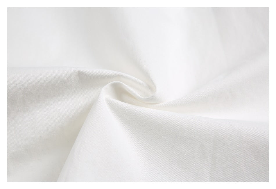 Close-up of white fabric gathered into soft folds, showing its fine surface texture.