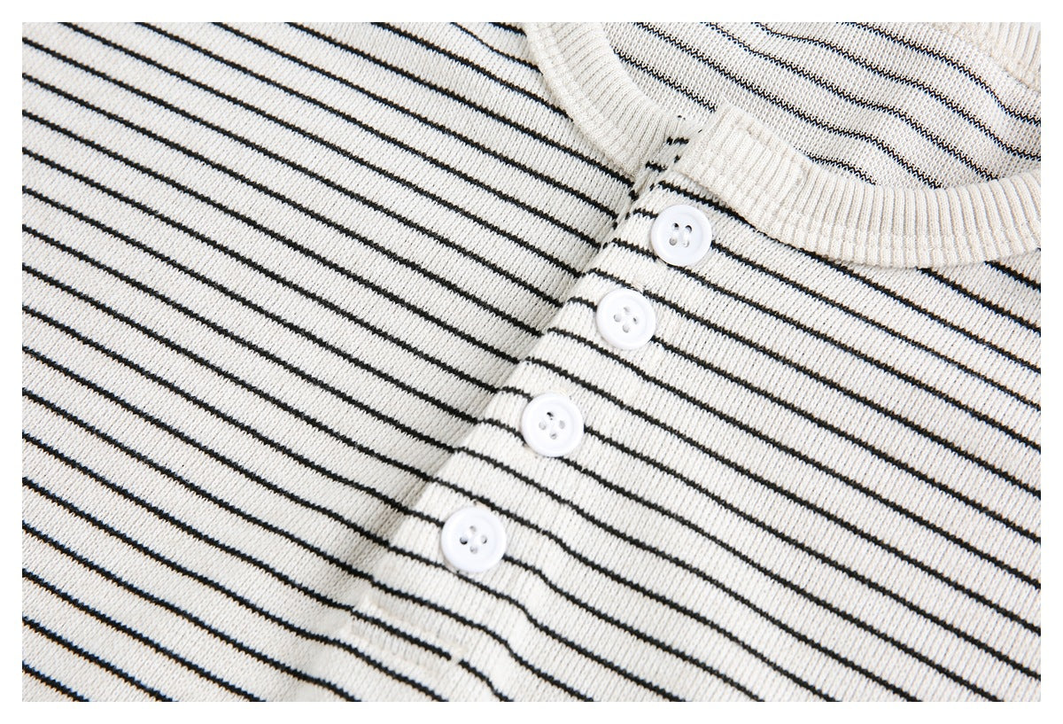 Close-up of the ivory striped T-shirt's four-button placket and ribbed crew neckline.