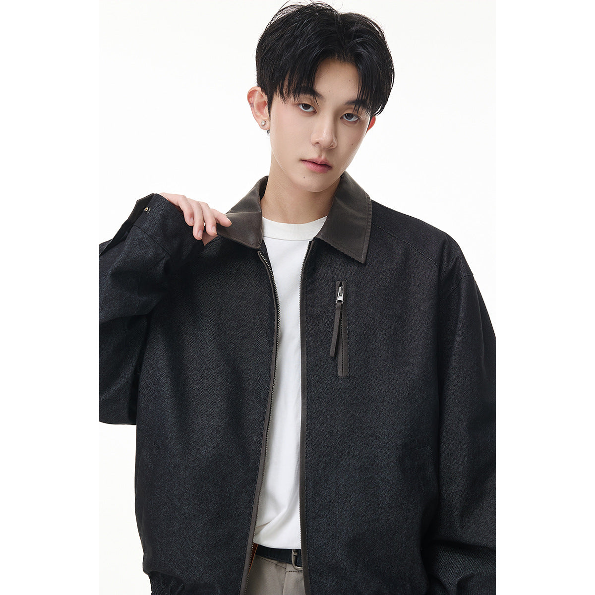 Close front view of a model wearing a charcoal jacket with a contrasting collar and vertical zip chest pocket.