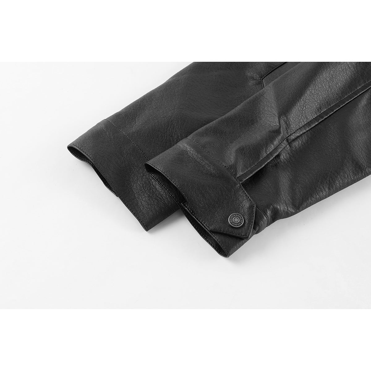 Close-up of a black jacket sleeve ending in a snap-button cuff.