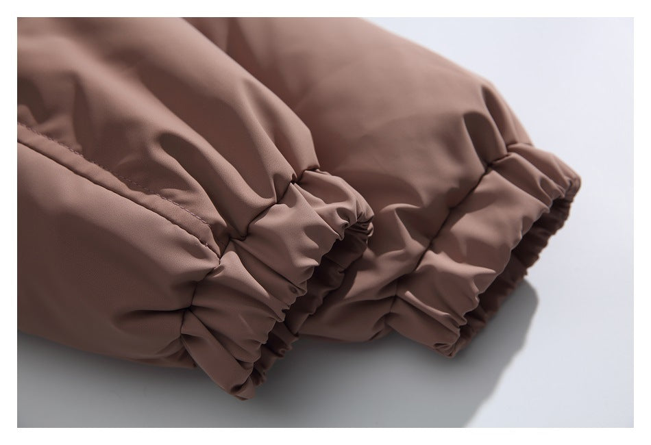 Close-up of a taupe-brown jacket sleeve with a gathered elastic cuff.