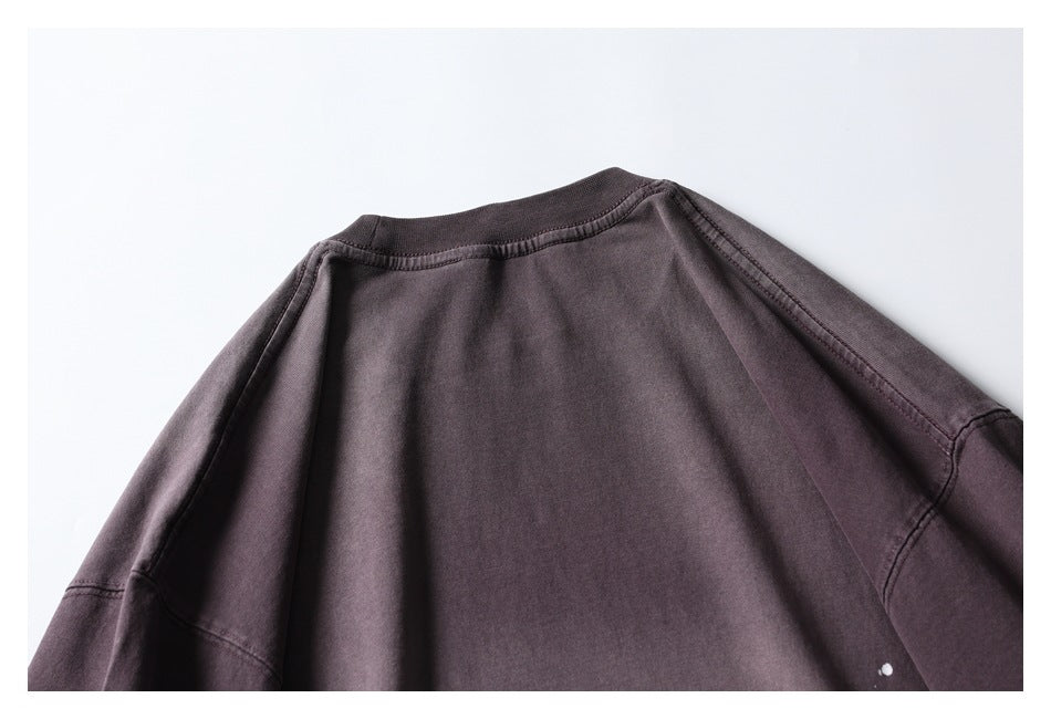 Close-up of the back neckline and shoulder seams of a dark plum-gray top.