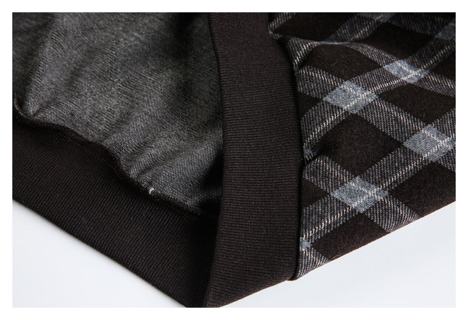 Close-up of a dark ribbed hem beside the gray plaid fabric and its inner side.
