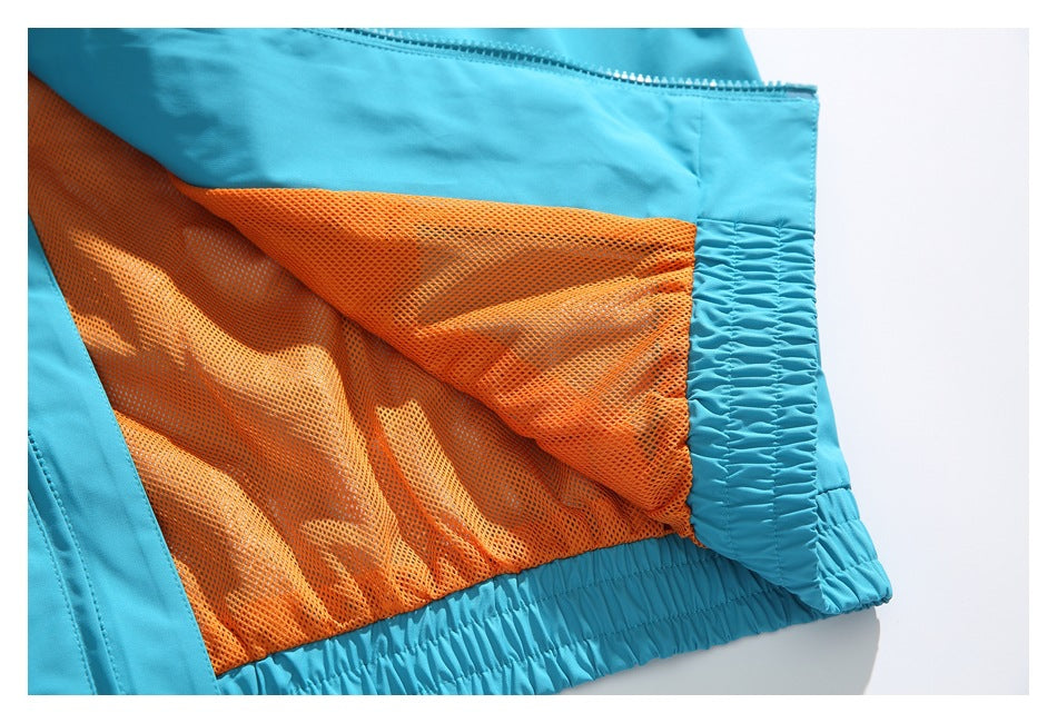 Close-up of turquoise garment interior with orange mesh panel, zipper, and gathered elastic edge.