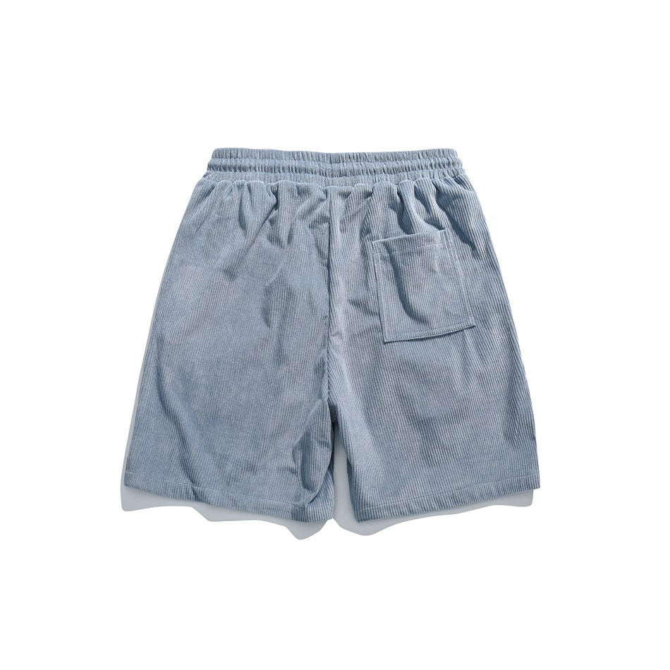 Back view of light blue corduroy shorts with an elastic waistband and a patch pocket.