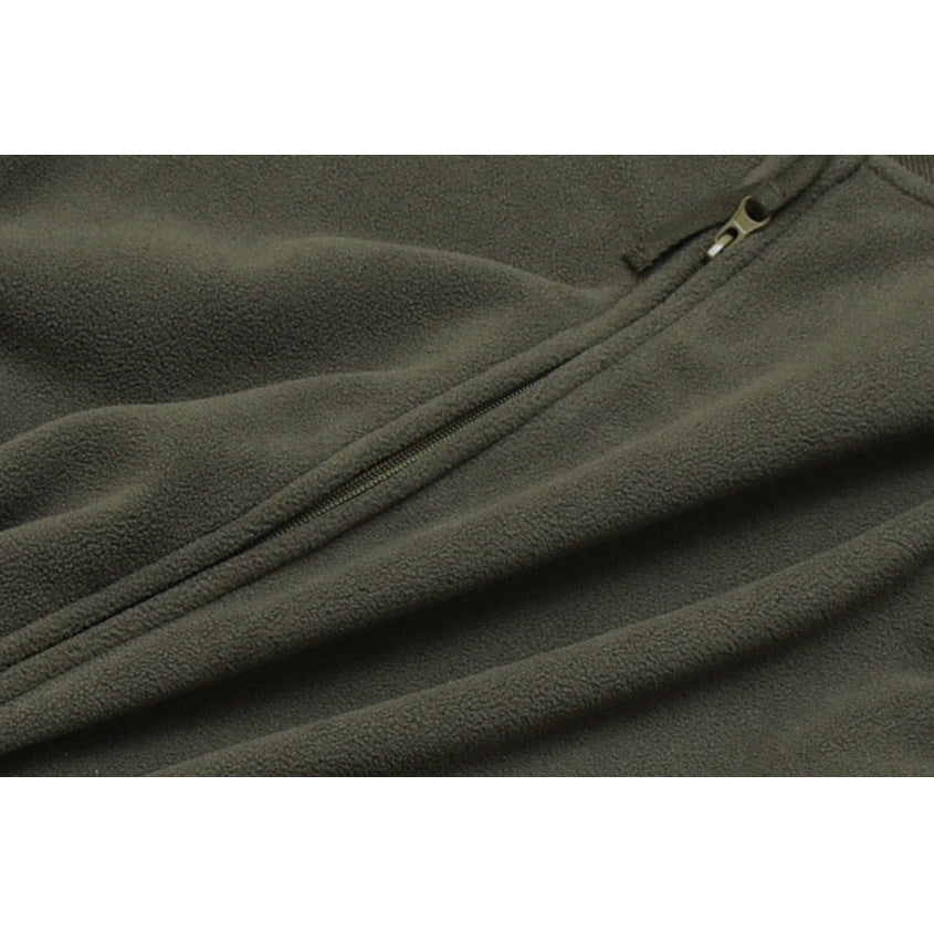 Close-up of the olive-gray jacket's zipper running diagonally across the fabric.