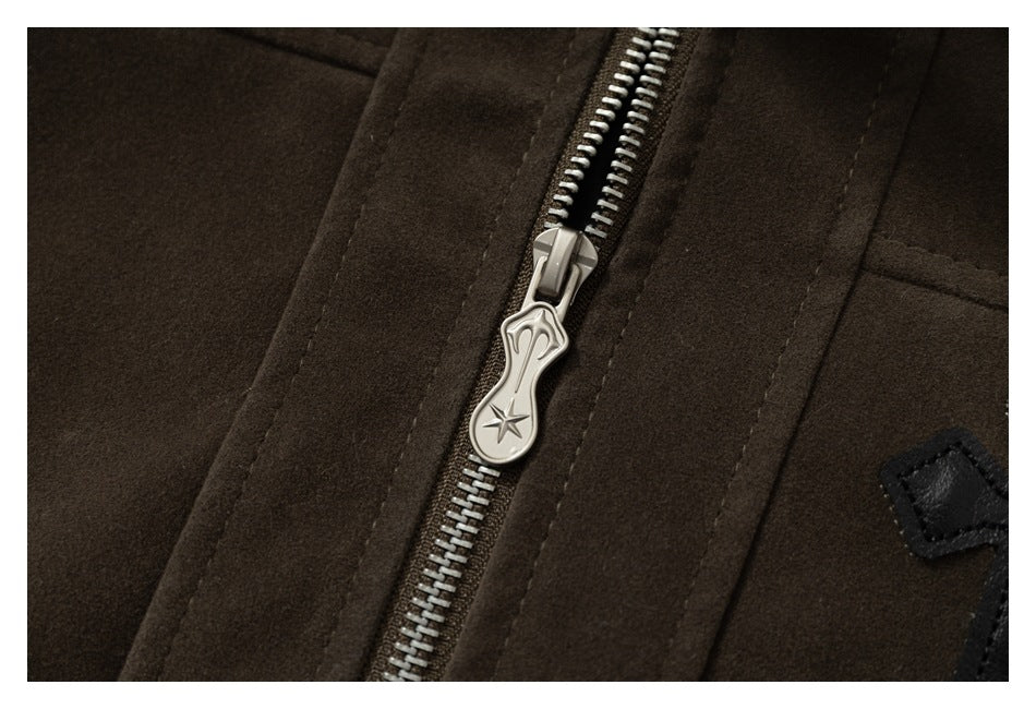 Close-up of a dark brown jacket's silver front zipper and decorative pull.
