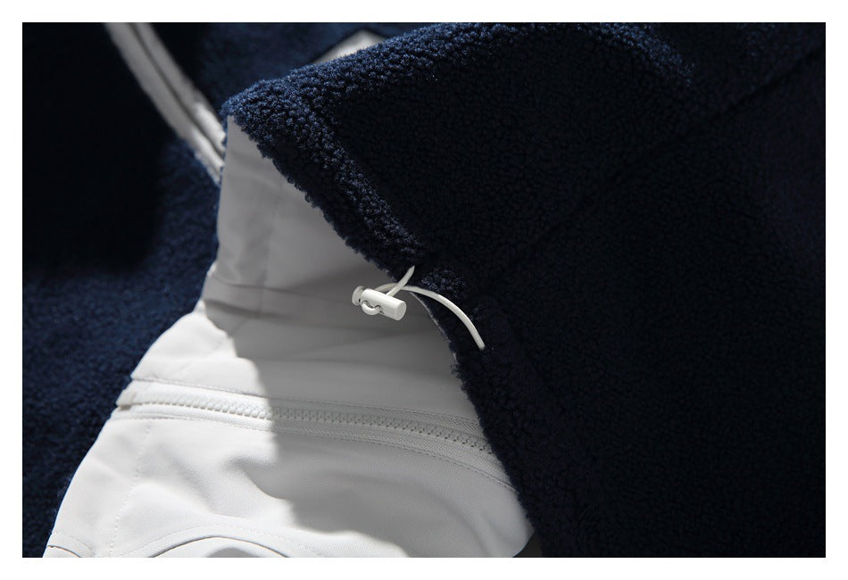 Close-up of a navy fleece jacket's white inner panel, zipper, and adjustable drawcord toggle.